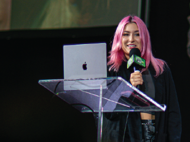 girl with pink hair holding microphone